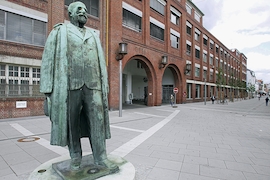 Adam-Opel-Statue vor dem Hauptportal des historischen Opelwerks im Zentrum von Rüsselsheim