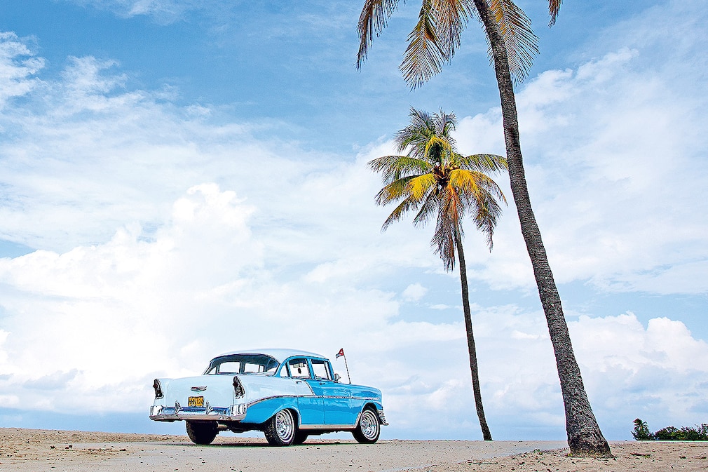56er Chevrolet BelAir von Yenima und Dairan unter Palmen am Playas del Este