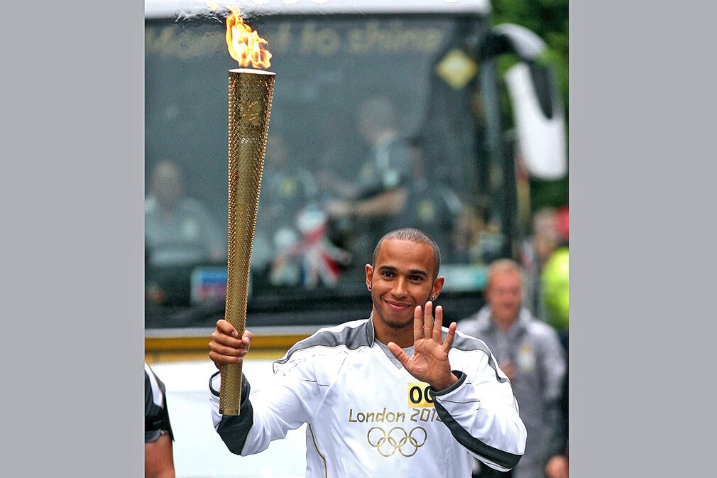 Formula One driver Lewis Hamilton carrying the Olympic Flame