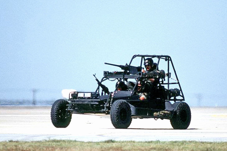 Three-members-of-a-U.S.-Navy-sea-air-land-(SEAL)-team-ride-in-a-Scorpion-fast-attack-vehicle-(FAV).-Mounted-on-the-vehicle-are-two-M-60E3-7.62mm-machine-guns,-front-and-rear,-and-an-M-2-.50-caliber-machine-gun.-On