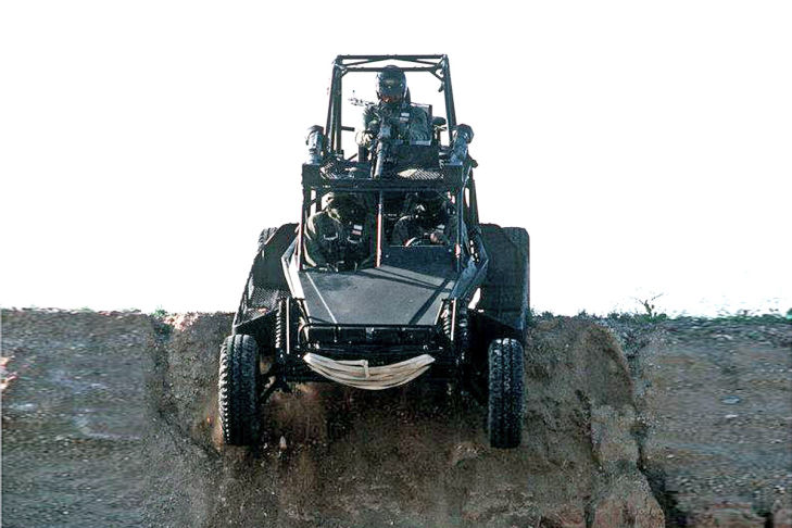 Members-of-Navy-Sea-Air-Land-(SEAL)-Team-5-prepare-to-go-over-a-ridge-in-a-SEAL-Team-3-Scorpion-fast-attack-vehicle-(FAV)-as-they-travel-across-the-desert-during-a-press-demonstration.-An-M-2-.50-caliber-machine-g