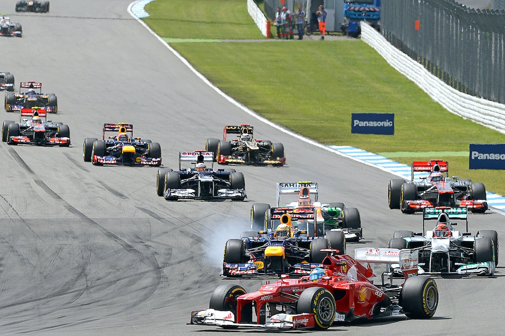 Spanish Formula One driver Fernando Alonso of Ferrari leads ahead of German Sebastian Vettel (L) of Red Bull who is attacked by his compatriot Michael Schumacher (R) of Mercedes AMG during the start of the Formula One Grand Prix of Germany at the Hockenheimring