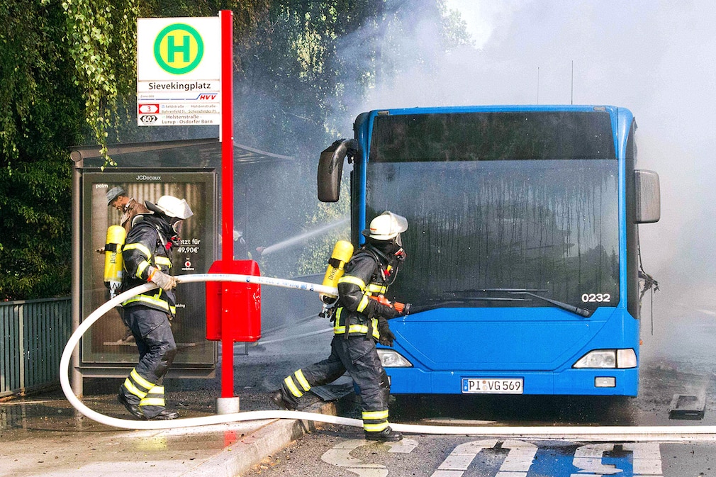 Feuerwehrleute löschen am Mittwoch (21.07.2010) in Hamburg einen brennenden Linienbus