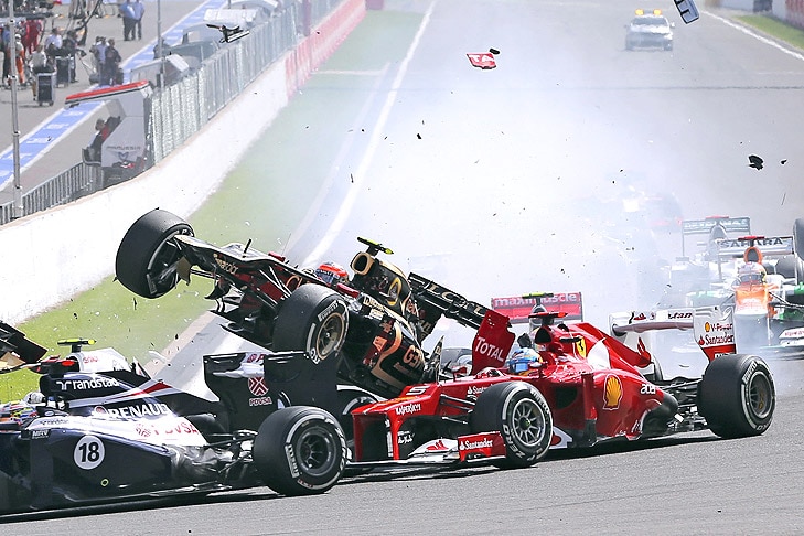 French Formula One driver Romain Grosjean (C) of Lotus crashes during the start of the 2012 Belgium
