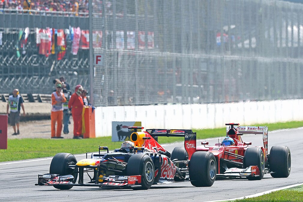 Spanish Formula One driver Fernando Alonso (R) of Ferrari tries to overtake German Sebastian Vettel of Red Bull