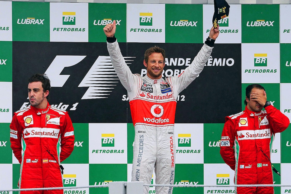 British Formula One driver Jenson Button (C) of McLaren Mercedes celebrates on the podium after winning the Formula One Grand Prix of Brazil