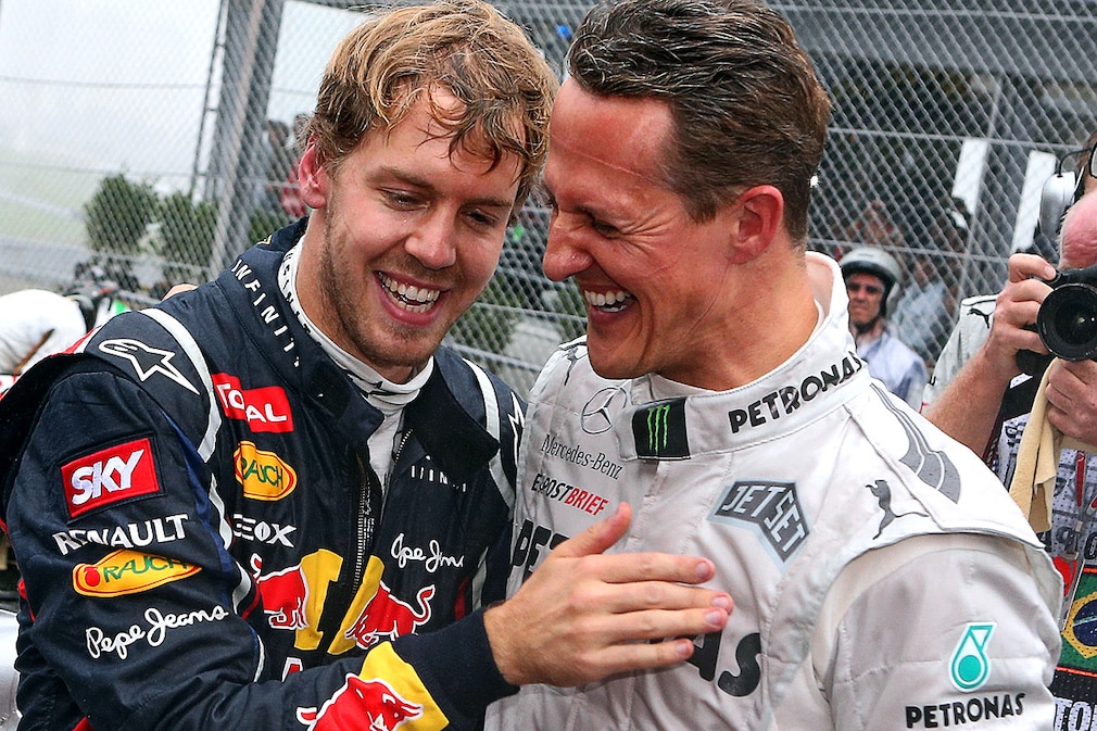 German Formula One driver Sebastian Vettel of Red Bull celebrates with German Formula One driver Michael Schumacher of Mercedes AMG his third world championship in a row after the Formula One Grand Prix of Brazil