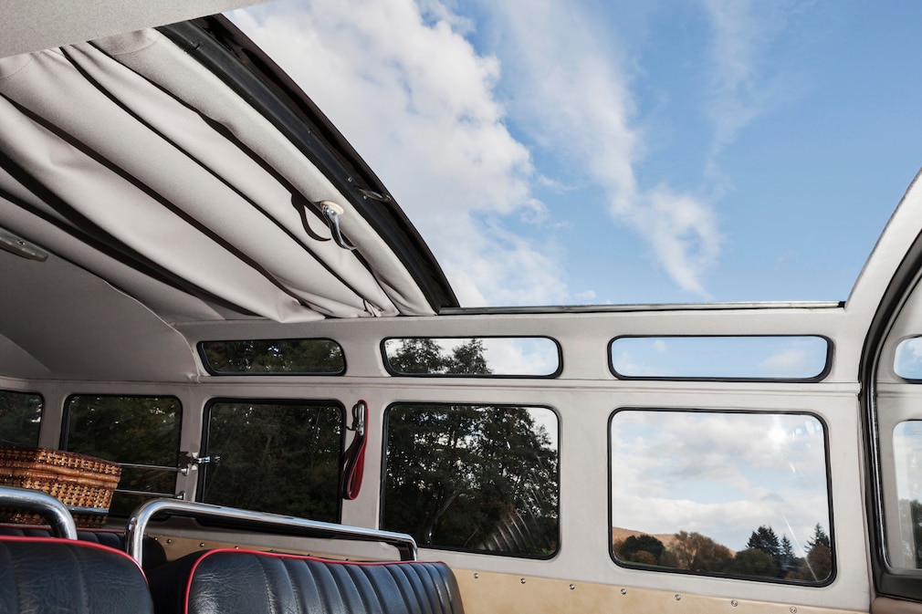 Blick von innen aus dem VW T1 Samba noch oben durch das offene Faltdach und die Dachrandverglasung