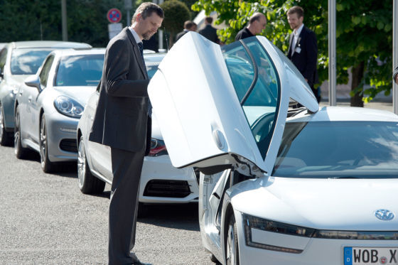 Ein Konferenzteilnehmer schaut sich beim E-Mobilitätskongress in Berlin ein VW Einliter-Auto an