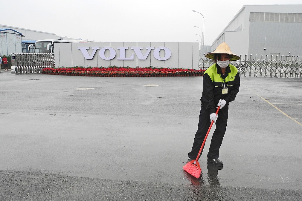 Eine Mitarbeiterin fegt am 05.06.2013 vor dem Gelände des ersten außereuropäischen Volvo-Werks in der südwestchinesischen Metropole Chengdu. Als erster Hersteller von Oberklassewagen plant Volvo Cars künftig auch Exporte aus seinem neuen Werk in China auf andere Weltmärkte