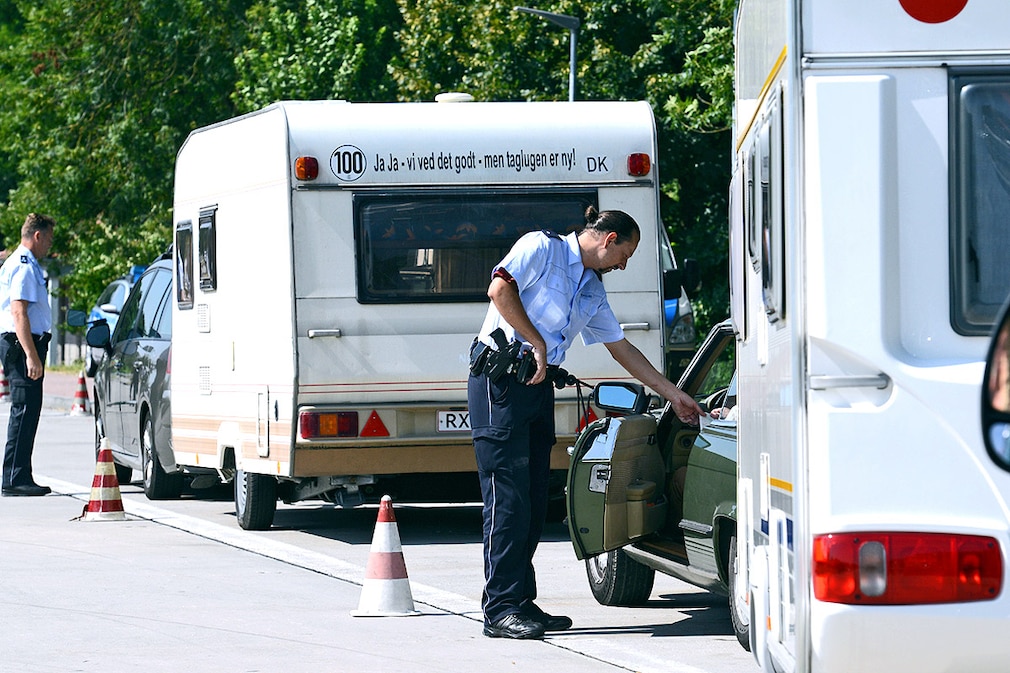 Zwei Polizeibeamte kontrollieren am 15.07.2013 an der A5 bei Neuenburg das Gewicht eines Wohnanhängers