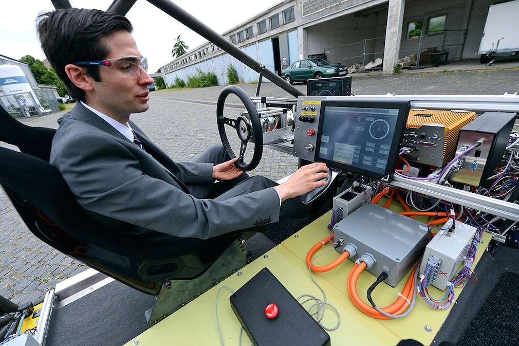 Die Forscher Markus Maurer (l) und Peter Bergmiller fahren am 26.06.2013 mit dem Elektroauto Mobile auf dem Gelände der Technischen Universität in Braunschweig