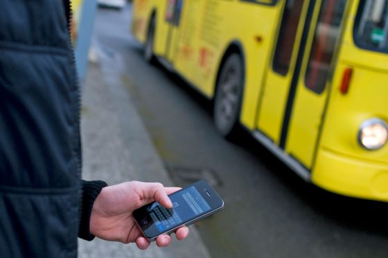 Smartphone vor gelbem Bus Smartphone vor gelbem Bus
