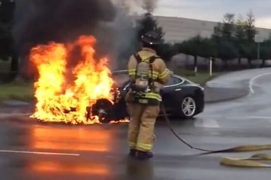 Ein Feuerwehrmann löscht ein brennendes Tesla Model S