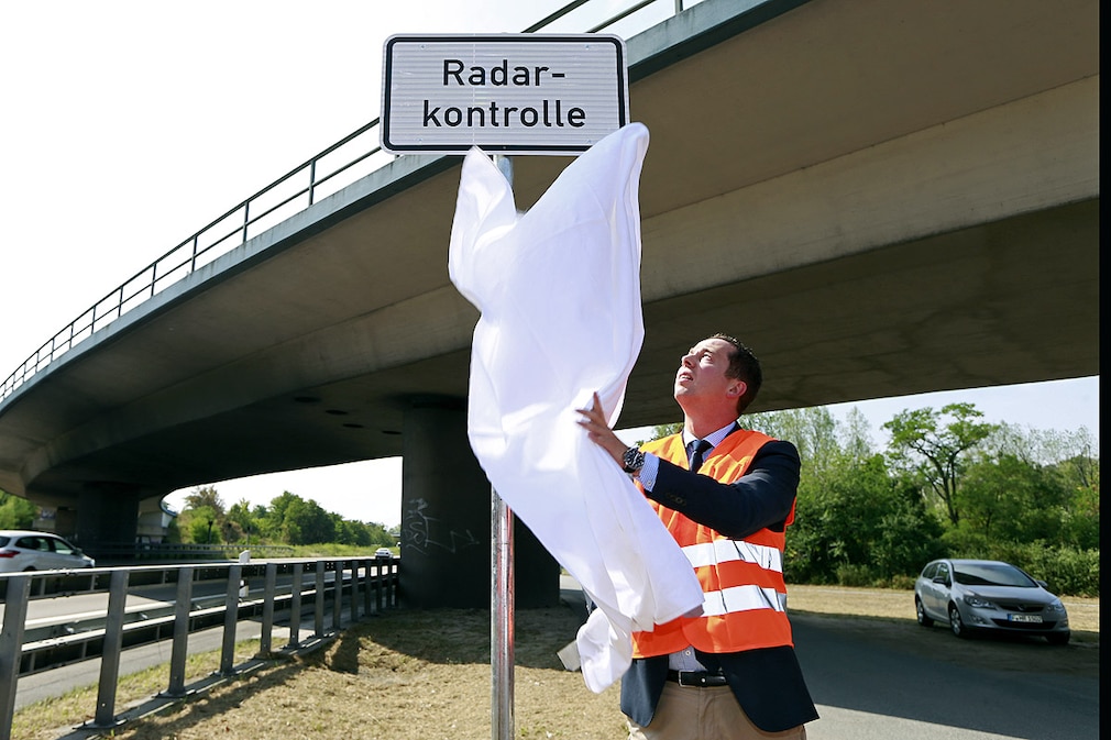 Hessens Verkehrsminister Florian Rentsch (FDP) enthüllt am 06.08.2013 am Autobahnkreuz Darmstadt ein Schild das vor einer Radarkontrolle warnen soll