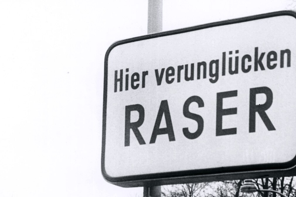 Ein Schild mit dem Text "Hier verunglücken Raser" mahnt Autofahrer im Düsseldorfer Vorort Eller das Tempo zu drosseln