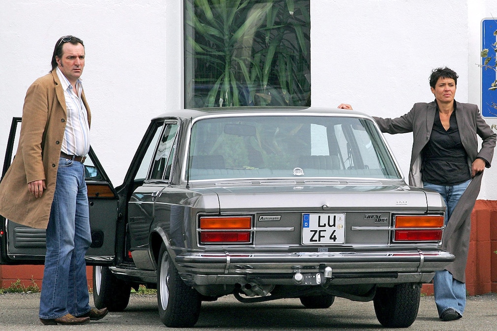 Die Schauspieler Andreas Hoppe und Ulrike Folkerts posieren am Donnerstag (07.04.2005) in einer Fabrikhalle in Karlsruhe bei Dreharbeiten zum SWR-Tatort mit dem Titel Unausweichlich für die Fotografen neben ihrem Dienstwagen Fiat 130 Limousine