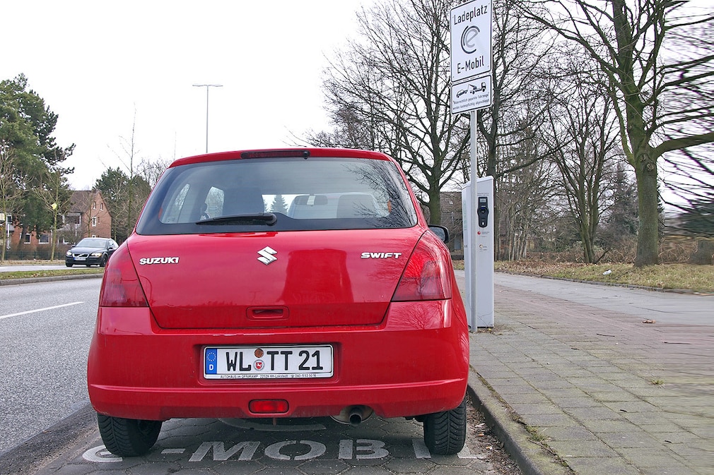 Auto auf Parkplatz mit Ladesäule