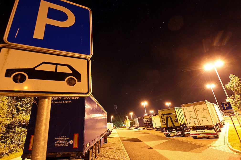 Lkw parkt abends in zweiter Reihe auf einer Raststätte