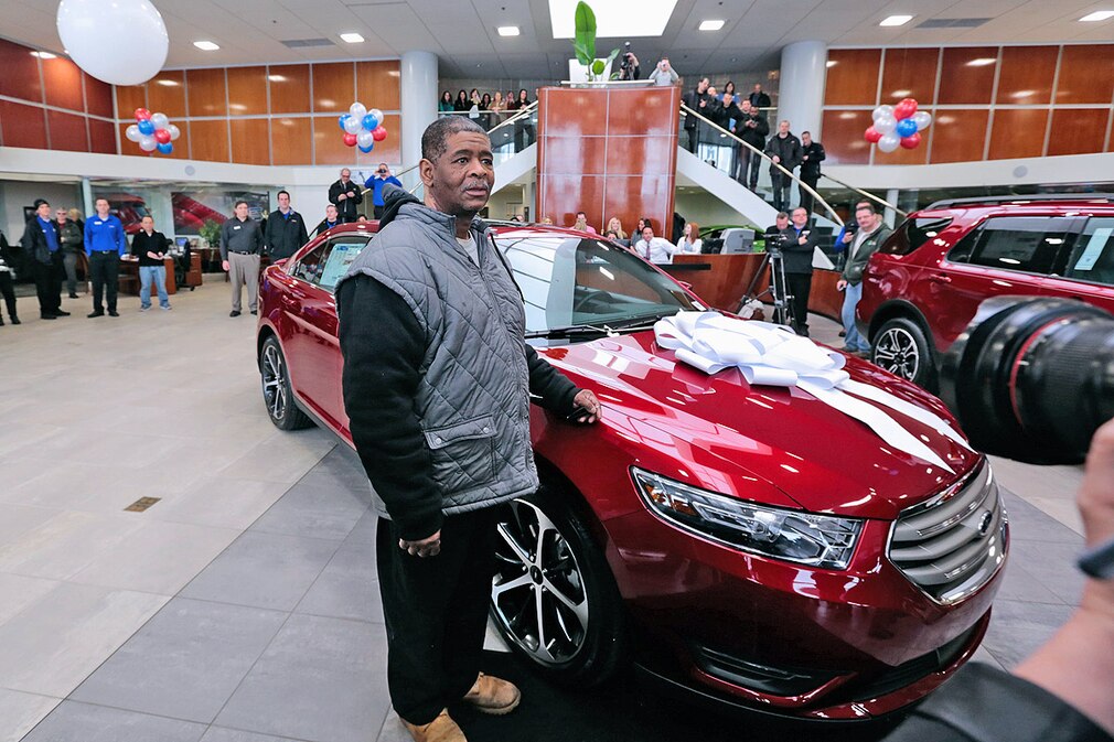 56-year-old factory worker, James Robertson, sits in his new car which was presented to him by Suburban Ford of Sterling Heights Michigan USA
