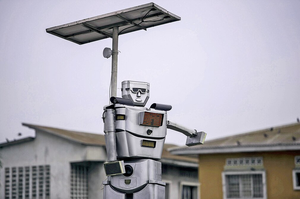 A newly installed solar powered Robtocop looks down over road users in Kinshasa Kongo