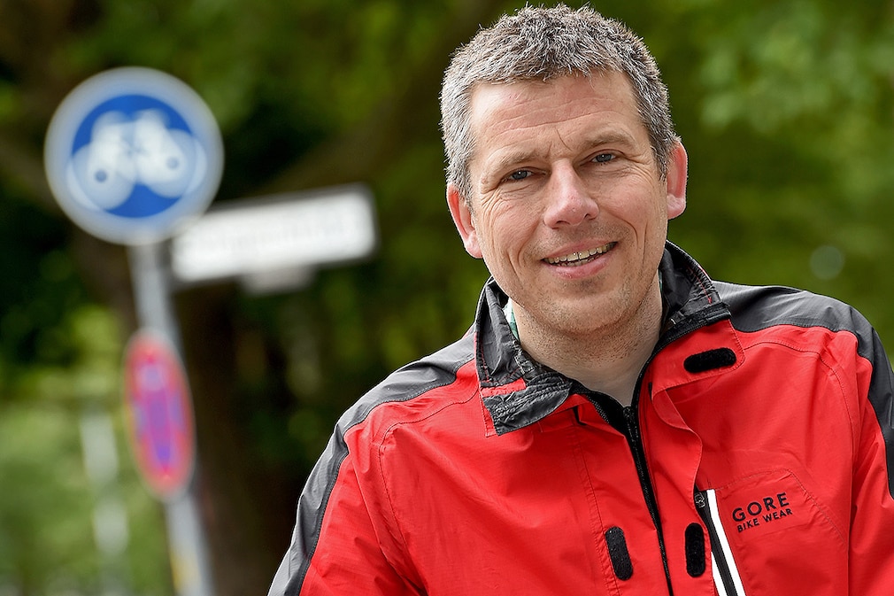 Der Anwalt Andreas Volkmann steht am 26.05.2015 in Berlin mit seinem Fahrrad vor einem Radweg der durch ein Fahrradschild gekennzeichnet ist. Foto: Britta Pedersen/dpa (zu dpa "Radfahren auf der Autospur - Mit den Großen schwimmen" vom 03.06.2015)