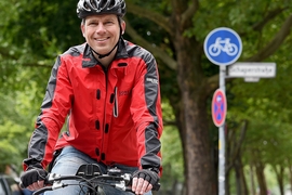 Der Anwalt Andreas Volkmann steht am 26.05.2015 in Berlin mit seinem Fahrrad vor einem Radweg der durch ein Fahrradschild gekennzeichnet ist.