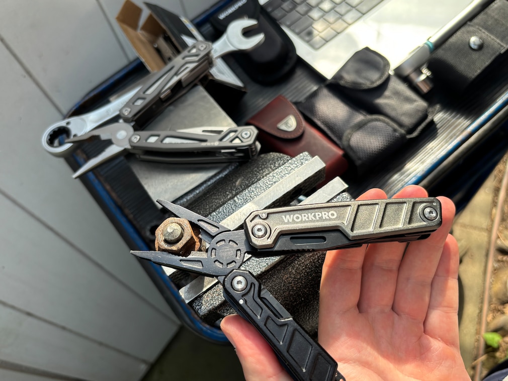 Demonstrationsfoto: ein Zangenwerkzeug mit weit geöffnetem Multitool, an eine große Schraubverbindung angesetzt.