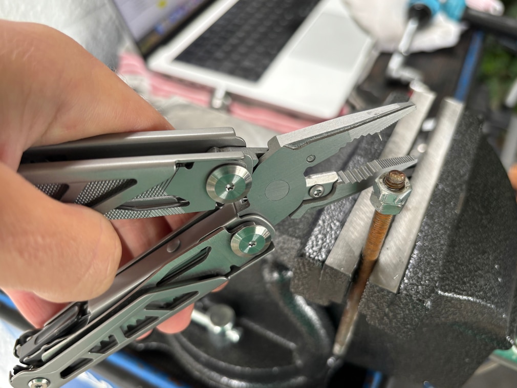 Perspektive auf ein in der Hand gehaltenes Multitool mit Blick auf die gezahnten Greifbacken.