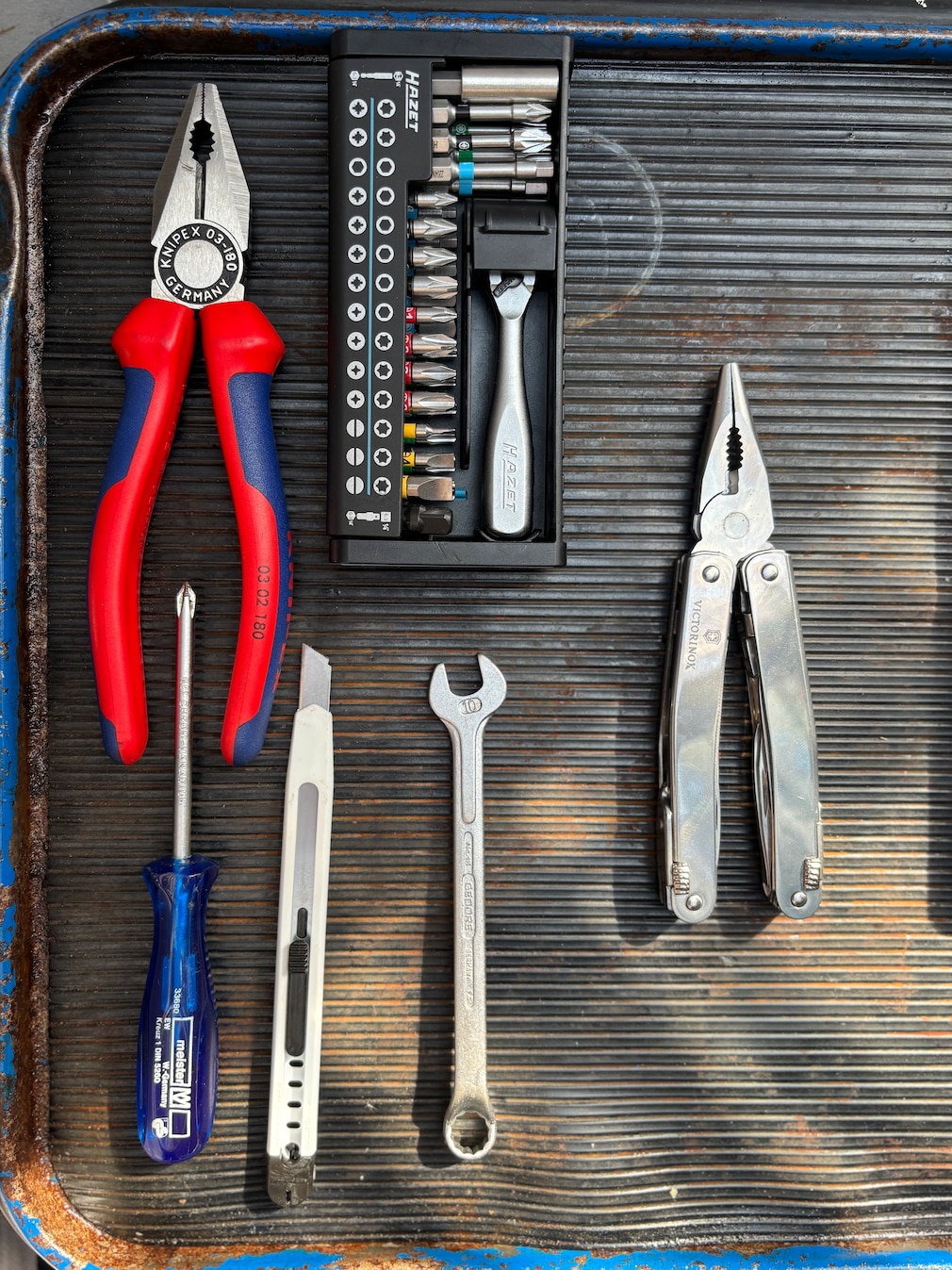 Symbolfoto: ein Multitool, daneben arrangiert die Werkzeuge, die sich in diesem Testprodukt vereint wiederfinden sollen.