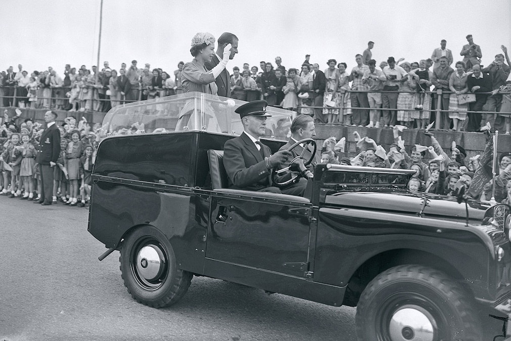 Queen Elizabeth II and the Duke of Edinburgh in a Land Rover driving up the length of the Albert Pier after landing from the Royal Yacht Britannia anchored in St. Aubin's Bay. Jersey