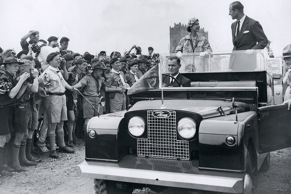 Queen Elizabeth II and the Duke of Edinburgh drive in an open Land Rover through the World Scout Jubilee Jamboree camp in Sutton Park