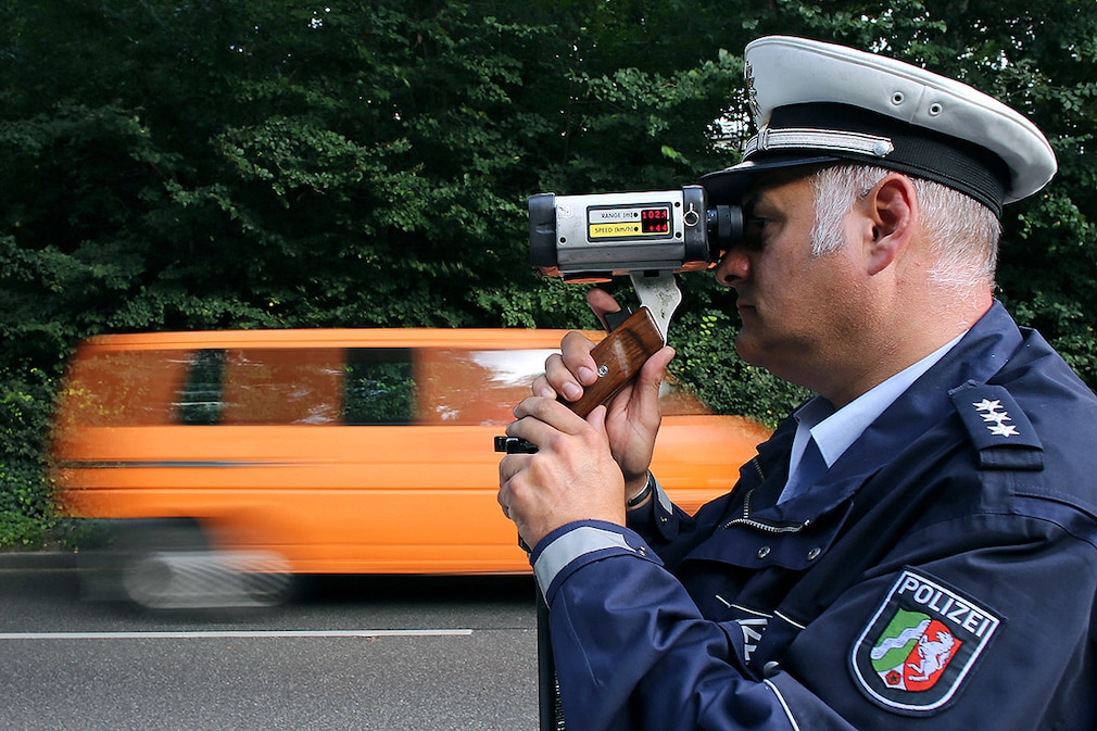 Ein Polizist misst am 01.09.2014 in Aachen mit einem Messgerät die Geschwindigkeit der Autofahrer