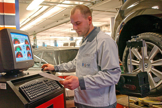 KFZ-Mechaniker in einem Fiat-Autohaus in Berlin, entnimmt einer Computeranalyse die Korrekturwerte für die Achsgeometrie an einem Fahrzeug. Die Vermessung der Achsgeometrie an Personenkraftwagen dient der Optimierung des Lenkverhaltens und der Spurtreue