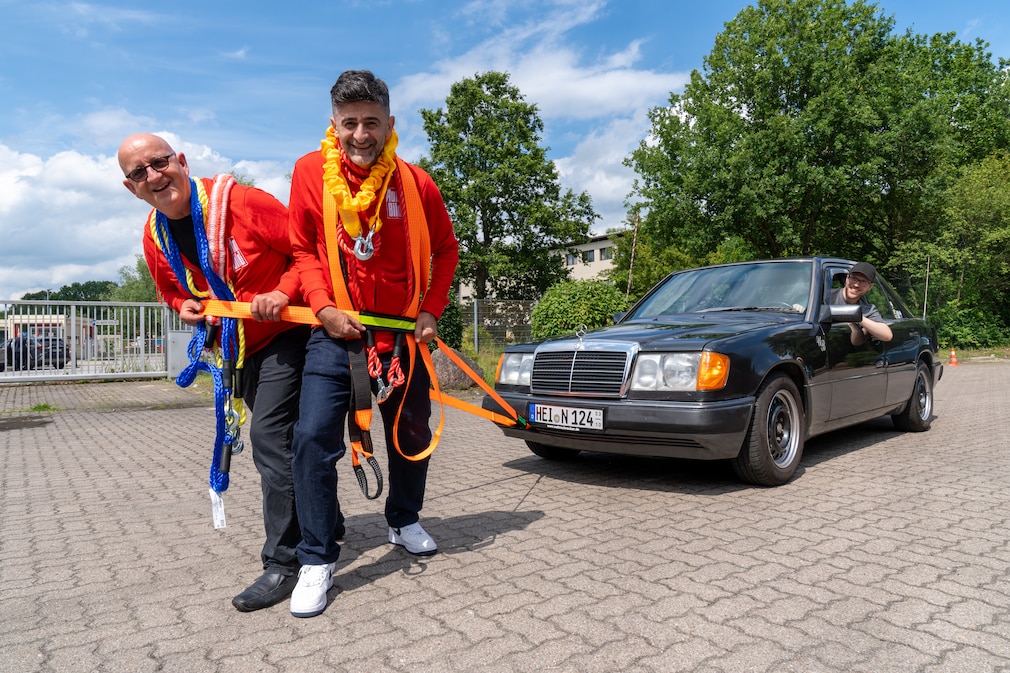 Redakteure ziehen mit verschiedenen Abschleppseilen einen Mercedes W124.