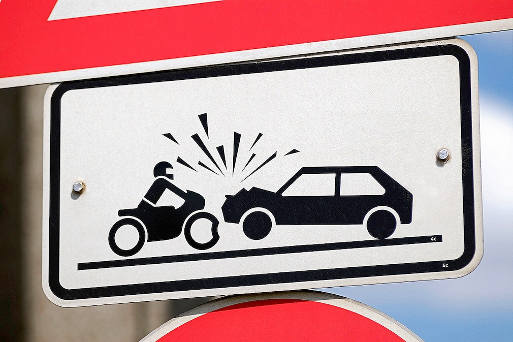 Verkehrsschild warnt vor Unfallgefahr mit Motorrad und Auto