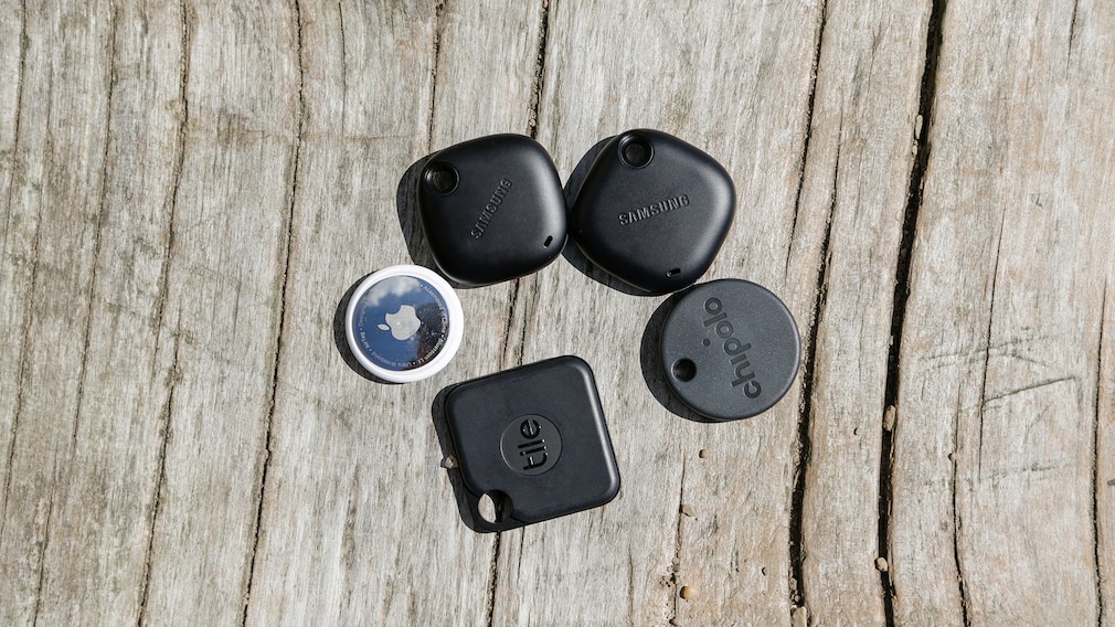 5 GPS-Tracker, angeordnet auf einer rauhen Holzfläche.