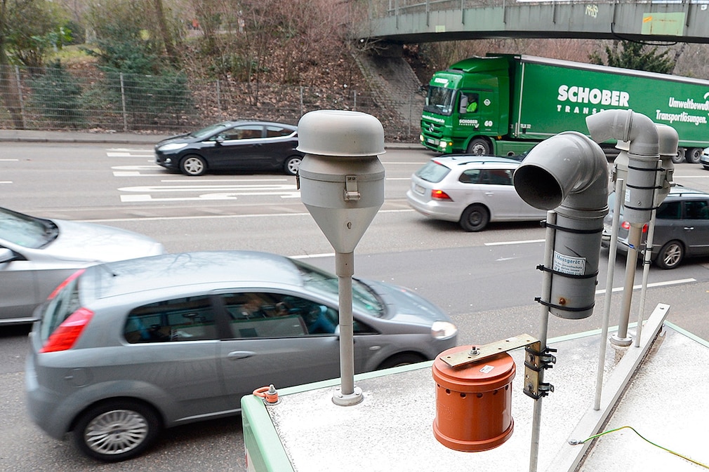 Autos fahren am 15.02.2017 an der Feinstaubmessstation "Am Neckartor" in Stuttgart (Baden-Württemberg) vorbei, während im Hintergund die Sonne unter geht.