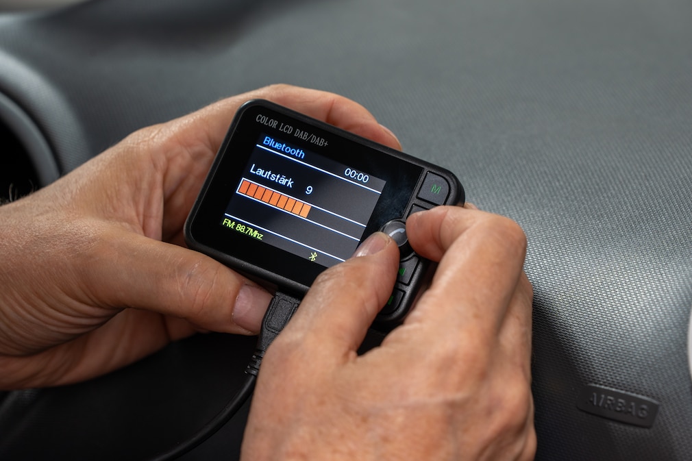 Darstellung der Einstellszene eines DAB+-Adapters, gehalten in der Hand