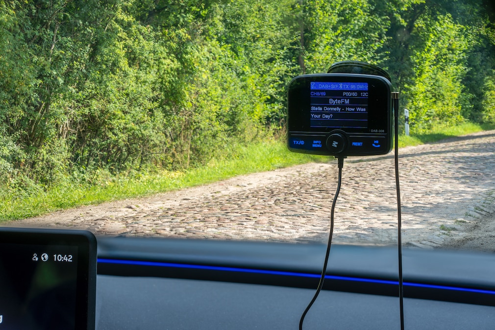 Halterungstest: Ein an der Frontscheibe angebrachter DAB+-Adapter, dahinter sichtbar eine Kopfsteinpflasterstrecke