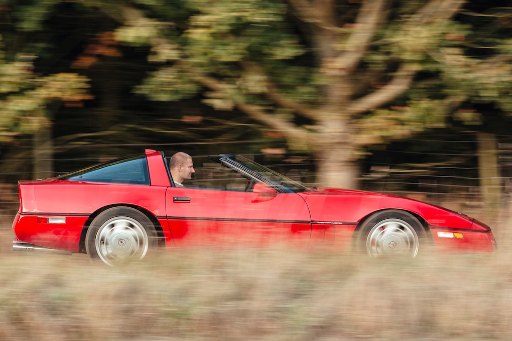 Chevrolet Corvette C4 Coupé in Rot, fahrend schräg von der Seite (Mitzieher)