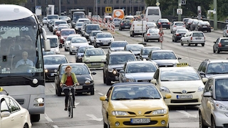Radfahrerin und Autos im Verkehr, Leipziger Straße, Berlin