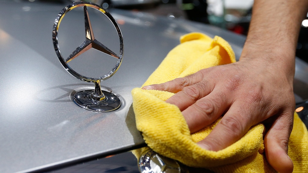 Mercedes-Haube wird mit Tuch geputzt Mercedes-Haube wird mit Tuch geputzt