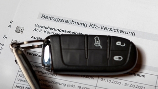 KFZ-Versicherung - Ein Autoschlüssel liegt auf einer Beitragsrechnung einer Kfz-Versicherung.