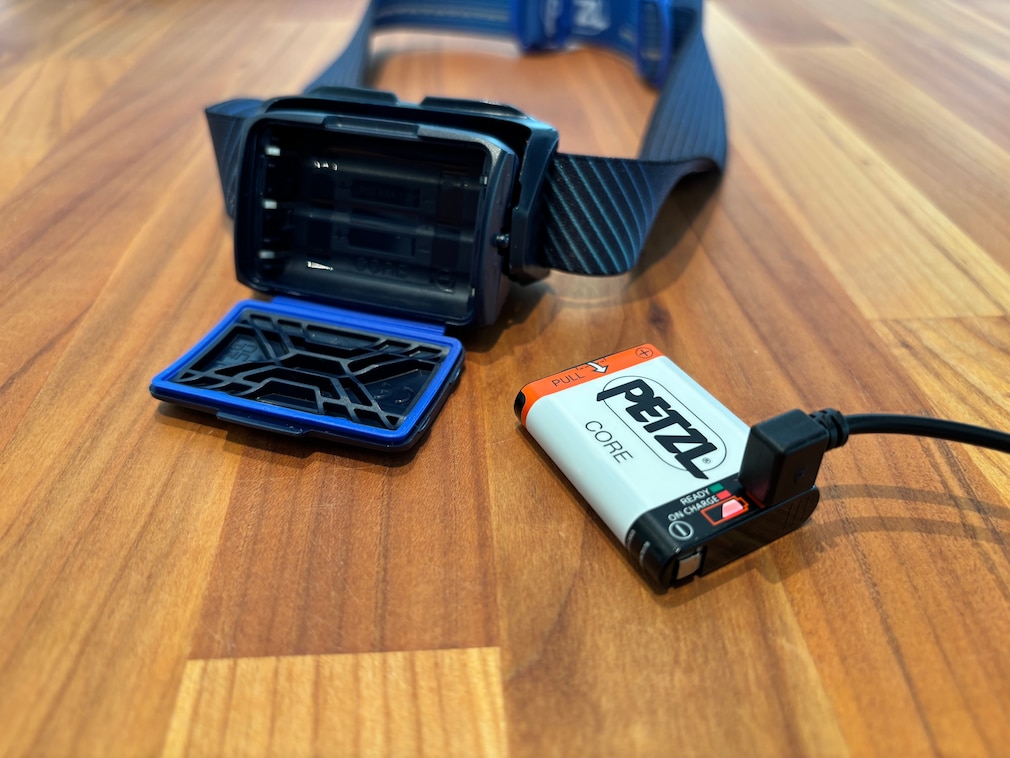 Akku der Petzl Core wird auf einem Tisch geladen.