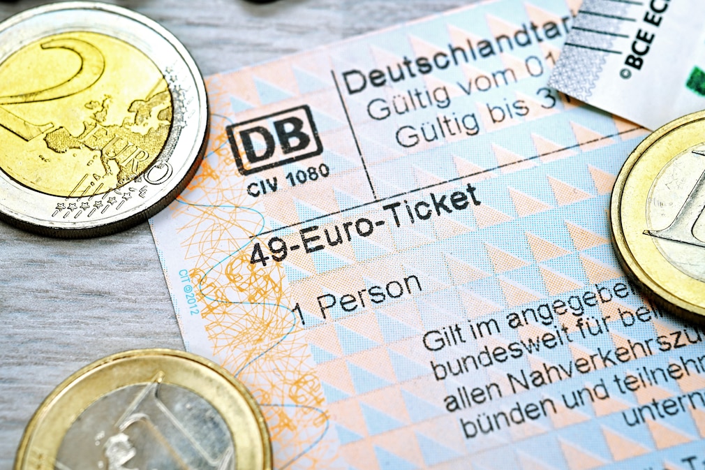 Fahrschein mit Aufschrift 49-Euro-Ticket und Euromünzen