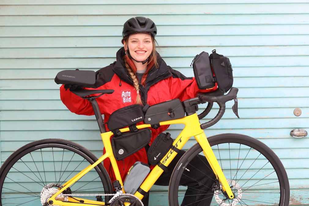 Testerin blickt mit einem Rennrad vor sich in die Kamera, alle Testmodelle sind am Rad und in den Händen zu sehen