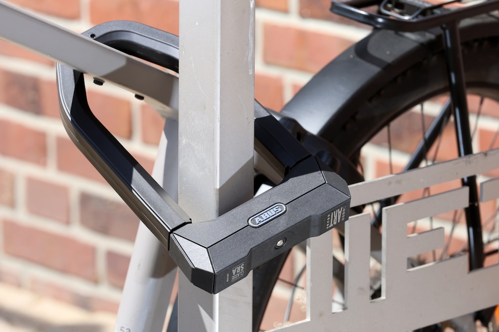Anschlusssituation mit Bügelschloss. E-bike im Anschnitt an Metallprofil