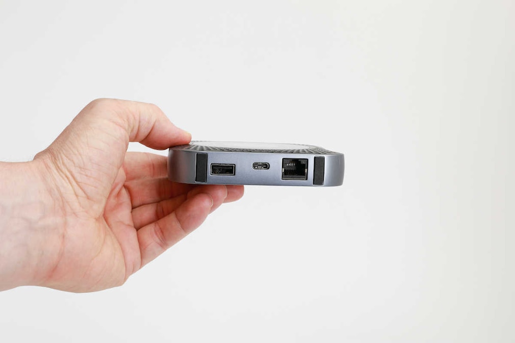 Eine Hand hält die Hardware-Anschlussseite der Netgear Nighthawk M1 vor neutralem Hintergrund dem Betrachter entgegen