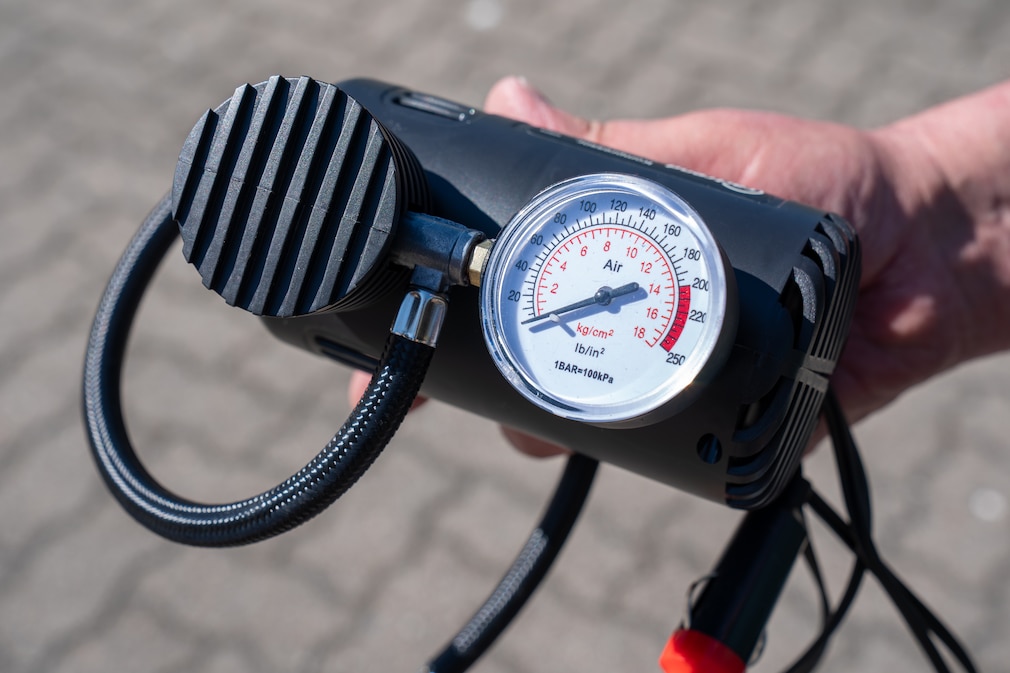 Nahaufnahme eines kleinen 12V Kompressor und dessen schlecht ablesbarer Skala.
